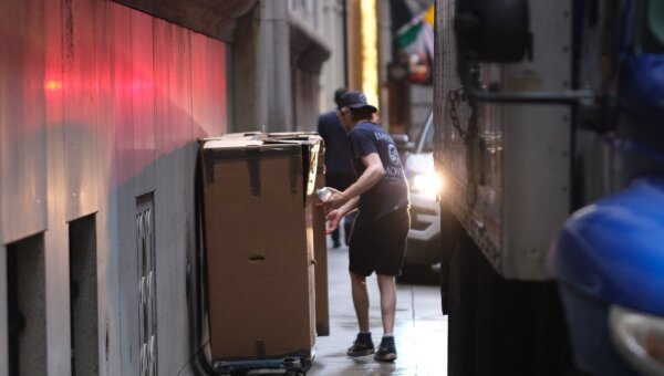 A professional mover placing a large box on a dolly