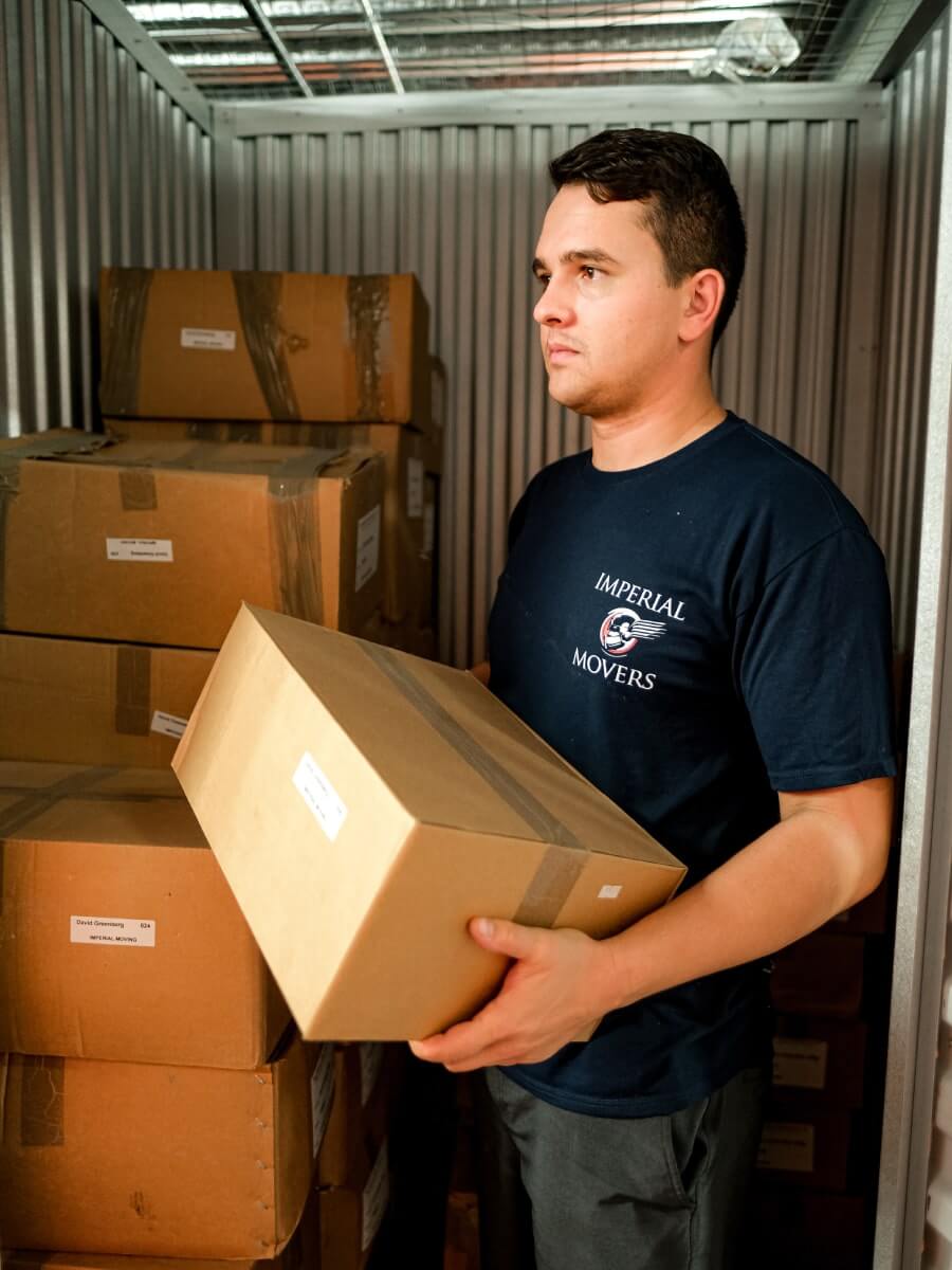 A professional male mover handling a box in a moving truck