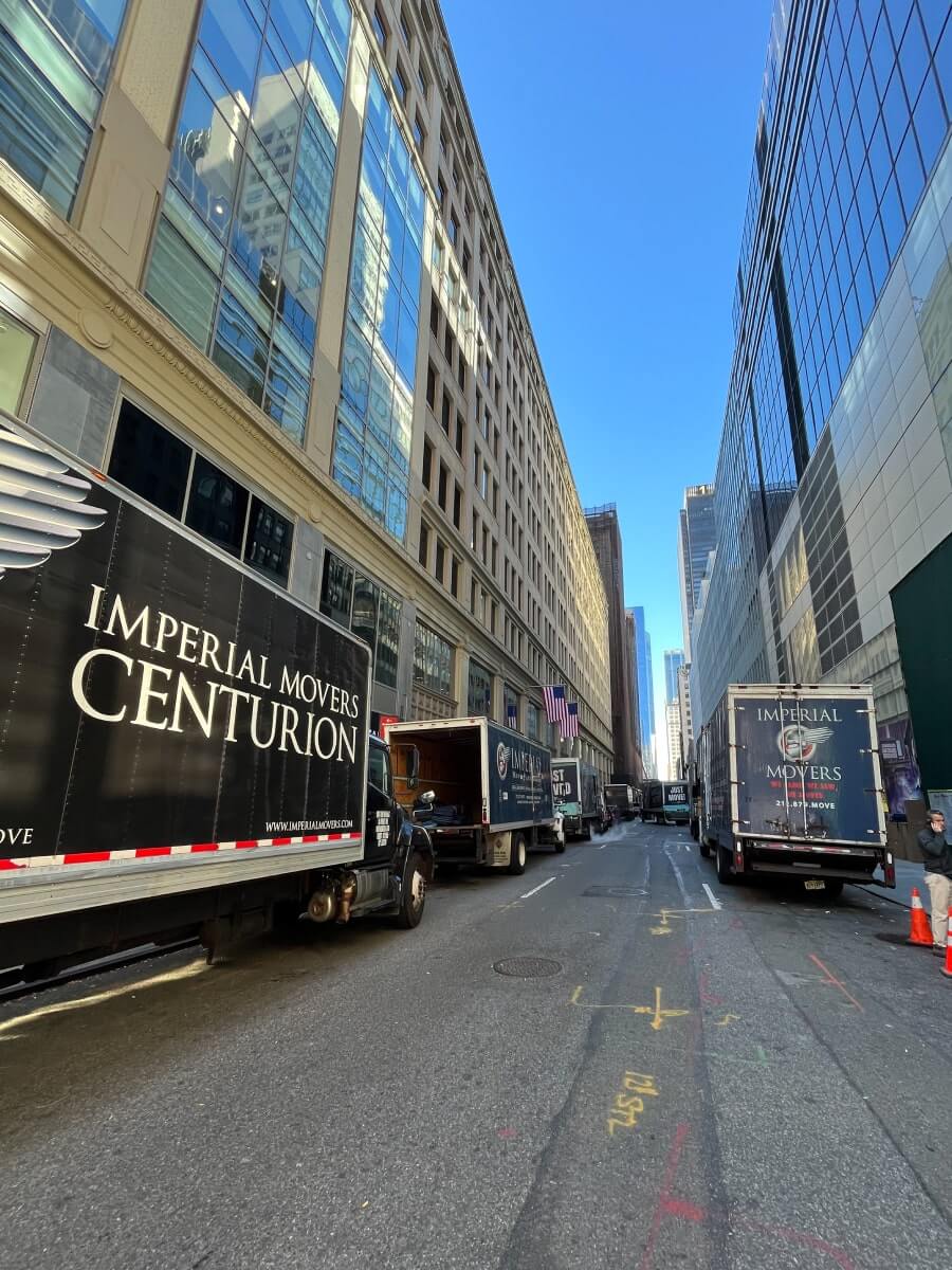 Professional moving trucks lined up in a narrow street 